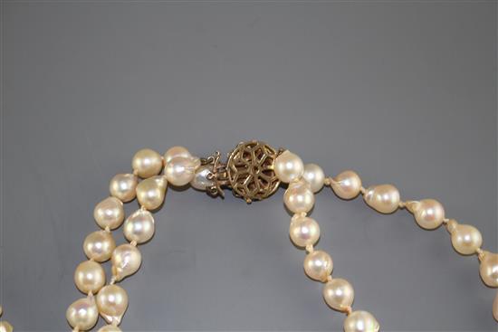 A double strand cultured baroque pearl necklace with yellow metal and garnet ? cluster clasp and one other simulated pearl necklace.